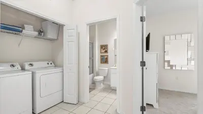 a white bathroom with a washer and dryer at Spacious Family Townhouse Sleeps 8 in Kissimmee