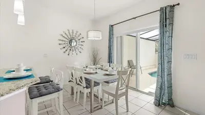 a white dining room with a white table and chairs at Spacious Family Townhouse Sleeps 8 in Kissimmee