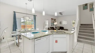 a kitchen with white cabinets and a counter top at Spacious Family Townhouse Sleeps 8 in Kissimmee