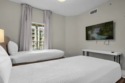 two beds in a white room with a window at 3 Bedroom Spacious Condo at WorldQuest near Disney- 22749 in Orlando