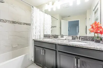 a bathroom with two sinks and a shower and a tub at Amazing Townhouse TVPM in Kissimmee