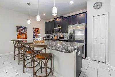 a kitchen with a counter with bar stools at Amazing Townhouse TVPM in Kissimmee