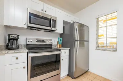 a kitchen with a stainless steel refrigerator and a microwave at Spectacular townhouse with themed room in Kissimmee
