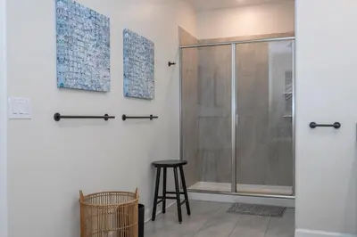 a shower stall with a stool in a bathroom at Ravello Villa Storey Lake in Kissimmee