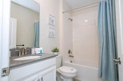 a bathroom with a sink and a toilet and a tub at Ravello Villa Storey Lake in Kissimmee