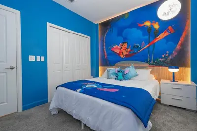 a blue bedroom with a bed with a painting on the wall at Villa Paradiso at Storey Lake in Kissimmee