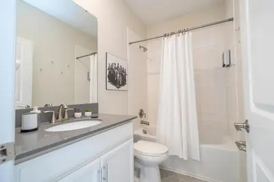 a white bathroom with a sink and a toilet at Villa Paradiso at Storey Lake in Kissimmee