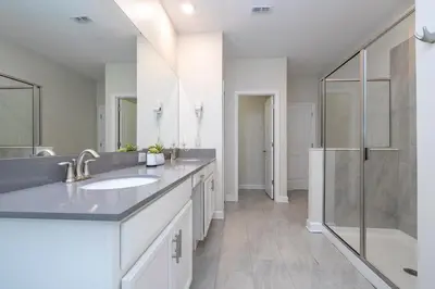a white bathroom with a sink and a shower at Villa Paradiso at Storey Lake in Kissimmee
