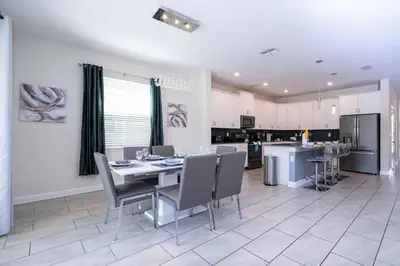 a kitchen and dining room with a table and chairs at Stunning Game Room & Pool Jacuzzi Storey Lake 2799 in Kissimmee