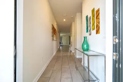 a hallway with white walls and a tile floor at Stunning Game Room & Pool Jacuzzi Storey Lake 2799 in Kissimmee