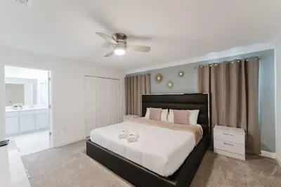 a bedroom with a large bed with a ceiling fan at Casa 4Q c Piscina Privativa Perto da Disney in Kissimmee