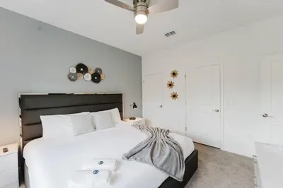 a white bedroom with a large white bed and white cabinets at Casa 4Q c Piscina Privativa Perto da Disney in Kissimmee