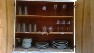 a cabinet filled with plates and bowls and dishes at Lakefront with Dock on Private Lake Florence near Montverde Academy in Montverde