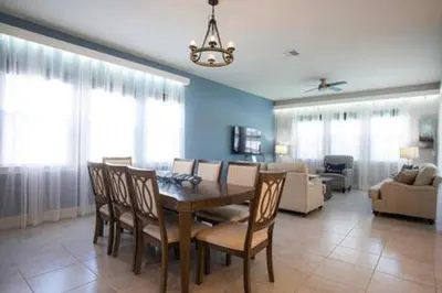 a dining room and living room with a table and chairs at Exclusive Orlando Getaway close to Disney in Kissimmee