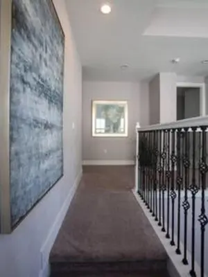a hallway with a staircase with a large painting on the wall at Exclusive Orlando Getaway close to Disney in Kissimmee