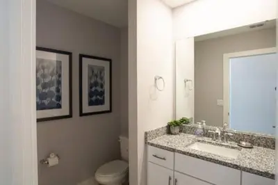a bathroom with a sink and a toilet and a mirror at Exclusive Orlando Getaway close to Disney in Kissimmee