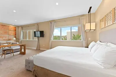a bedroom with a large white bed and a living room at Magic Views Excelente 4 Suítes Perto da 192/Disney in Orlando