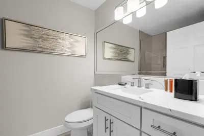 a white bathroom with a toilet and a sink at WorldQuest Resort in Orlando