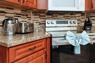 a kitchen with a stove with a blue bow on it at Ideal for Couples or Families looking for a Vacation Home with Private Pool and Yard in Kissimmee
