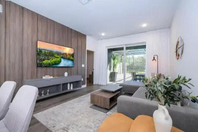 a living room with a couch and a tv on a wall at Doppio Westside in Orlando