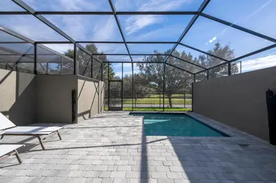 a swimming pool in a glass house with a roof at Doppio Westside in Orlando