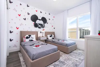 a bedroom with two beds and a cow decal on the wall at Doppio Westside in Orlando