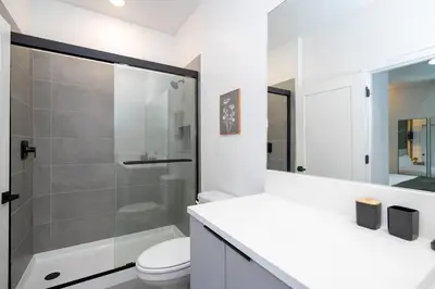 a white bathroom with a shower and a toilet at Doppio Westside in Orlando