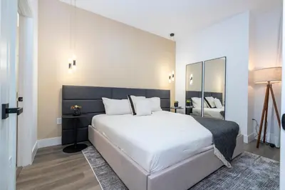 a bedroom with a large white bed and a mirror at Doppio Westside in Orlando