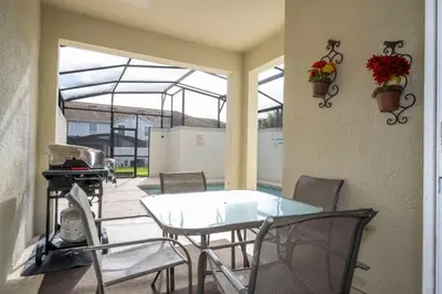 a patio with a table and chairs and a grill at Nice Vacation Townhouse w Pool SL4893 in Kissimmee