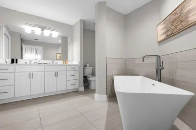 a white bathroom with a tub and a sink at Unit 5203 Worldquest in Orlando