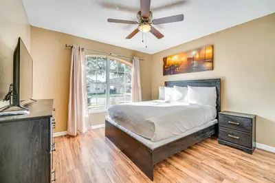 a bedroom with a bed and a ceiling fan at 8 Mi to Disney Parks Poolside Paradise! in Kissimmee