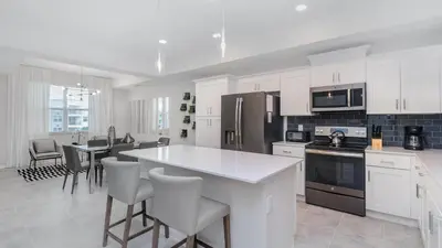 a kitchen with white cabinets and a table and chairs at PXC3180-303 in Kissimmee