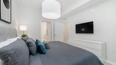 a bedroom with a bed with blue pillows and a tv at PXC3180-303 in Kissimmee