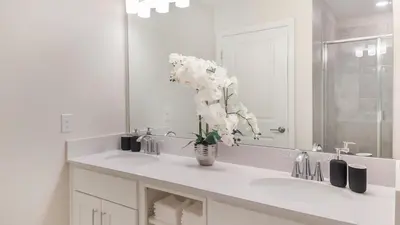 a bathroom with a sink with a vase of flowers at PXC3180-303 in Kissimmee