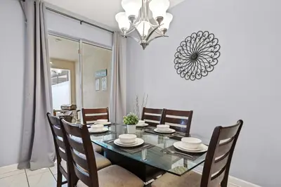 a dining room with a table with chairs and a chandelier at Spacious 4BR Townhome with Pool at Storey Lake in Kissimmee
