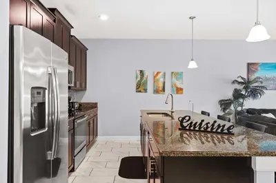 a kitchen with a stainless steel refrigerator and a counter at Spacious 4BR Townhome with Pool at Storey Lake in Kissimmee