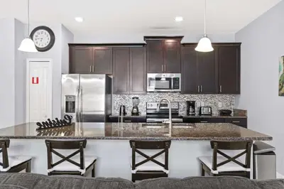 a kitchen with wooden cabinets and a large counter top at Spacious 4BR Townhome with Pool at Storey Lake in Kissimmee