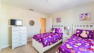 a bedroom with a purple bed and a dresser at Storey Lake Resort Vacation Townhome - includes resort clubhouse 0753 in Kissimmee