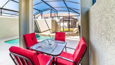 a patio with red chairs and a glass table at Storey Lake Resort Vacation Townhome - includes resort clubhouse 0753 in Kissimmee