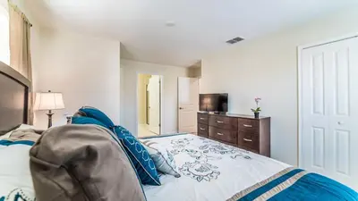 a bedroom with a bed and a dresser and a television at Storey Lake Resort Vacation Townhome - includes resort clubhouse 0753 in Kissimmee