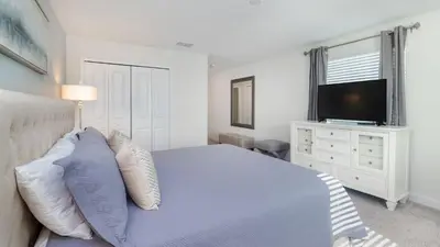 a bedroom with a bed with a television and a dresser at KCC 4797 in Kissimmee