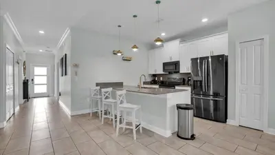 a kitchen with white cabinets and stainless steel appliances at QTS4361 in Kissimmee
