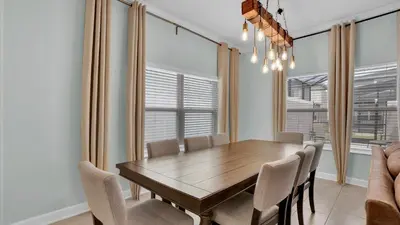 a dining room with a wooden table and chairs at QTS4361 in Kissimmee