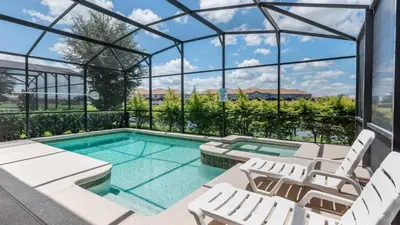 a swimming pool with white lounge chairs and a glass house at KCC4741 in Kissimmee