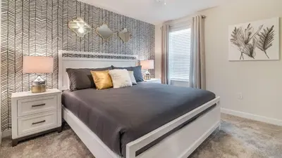 a bedroom with a large bed and a night stand at NRL4543 in Kissimmee