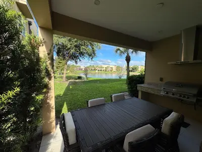 a patio with a table and chairs and a view of a yard at Magical & Spacious Home Minutes from Disney Parks in Orlando