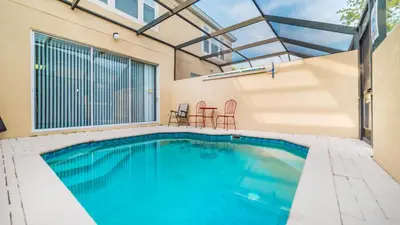 a swimming pool with two chairs and a table at Windsor Hills 3 Bedroom Private Pool Townhome 0865 in Orlando