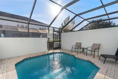a swimming pool with two chairs and a table at Windsor Hills 3 Bedroom Private Pool Townhome 0866 in Orlando