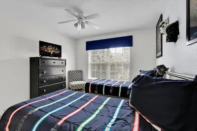 a bedroom with a bed and a dresser and a window at Windsor Hills Resort 5 Bedroom Updated Pool Home 0853 in Orlando