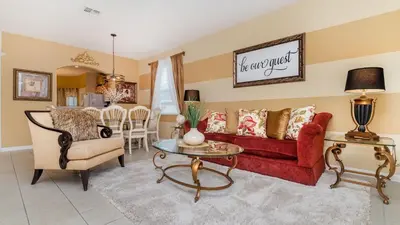 a living room with a red couch and a table at Windsor Hills Resort 6 Bedroom Home Incredible Game Room 0852 in Orlando